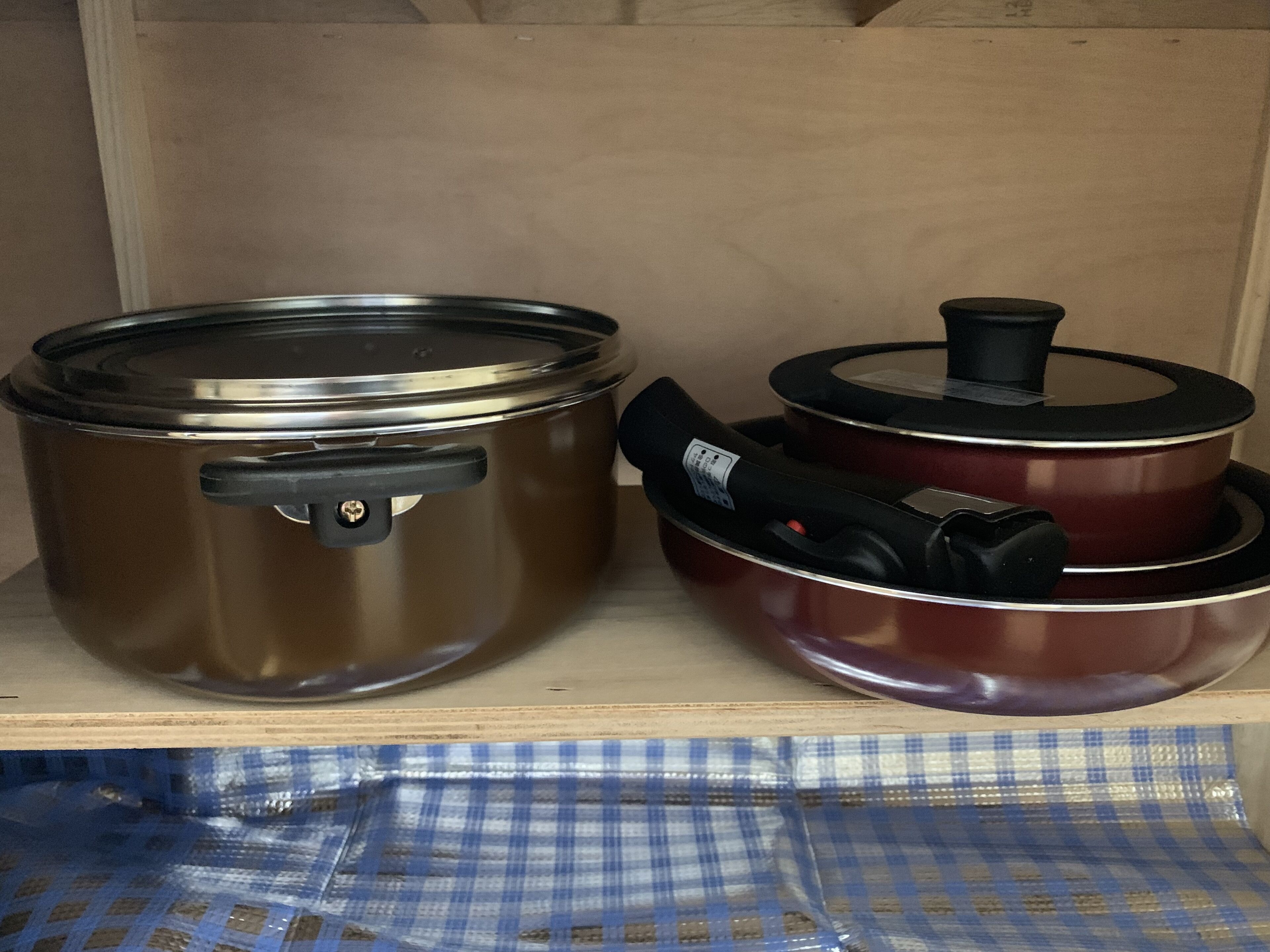 Due pentole d'acciaio inox su un ripiano di legno.