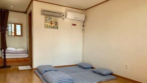 Ein Zimmer mit einem Bett, einer Klimaanlage und einem Bild an der Wand.