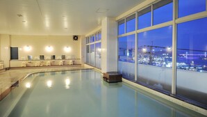 Ein großes Hallenbad mit Blick auf die Stadt bei Nacht.
