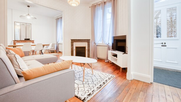 A modern living room with a sofa, a coffee table, and a fireplace. - Maison bourgeoise Haussmannienne (Gîtes de France) (Limoges)