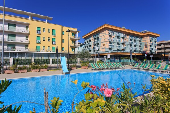 Piscine extérieure en saison, chaises longues, maître nageur