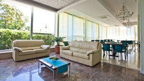 Un vestíbulo espacioso con un sofá color beige, una mesita de centro y una planta en maceta.