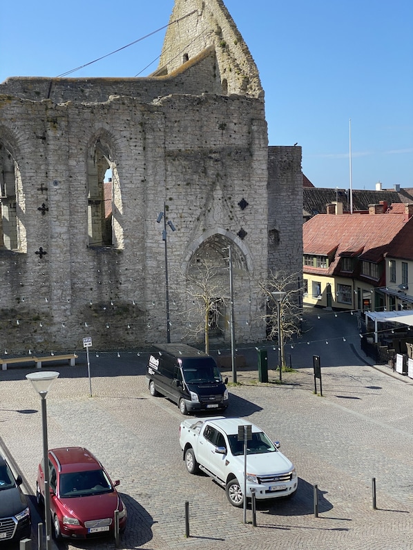 A historic stone building with arched windows and a tower. - Visby City Apartments (Visby)