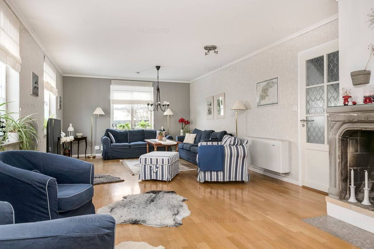 A living room with a fireplace, sofas, a coffee table, and a rug.