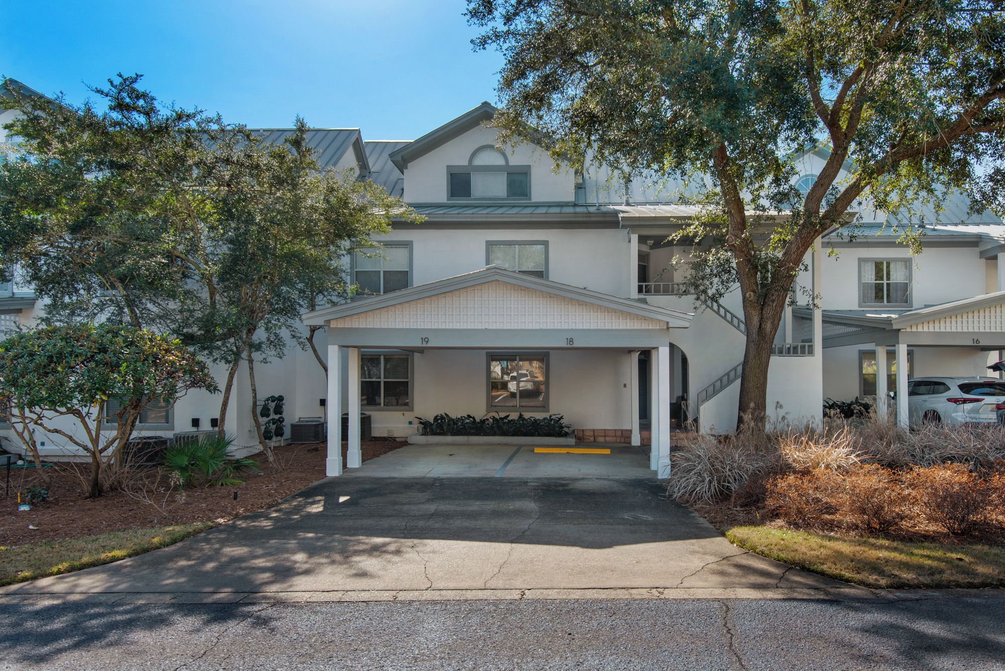 A two-story building with a covered entrance and a driveway leading to the parking area.