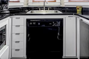 Eine moderne Küche mit Geschirrspüler, Backofen und Spüle aus Edelstahl.