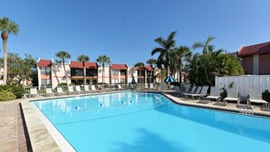 A swimming pool with lounge chairs and palm trees. - Runaway Bay Resort by BBG (Bradenton Beach)