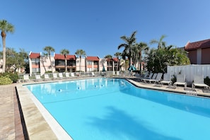 A swimming pool with lounge chairs and palm trees. - Runaway Bay Resort by BBG (Bradenton Beach)