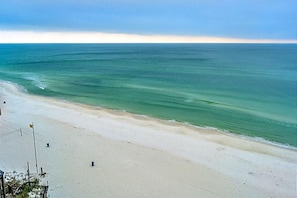 Una playa con una amplia orilla arenosa y mar tranquilo.