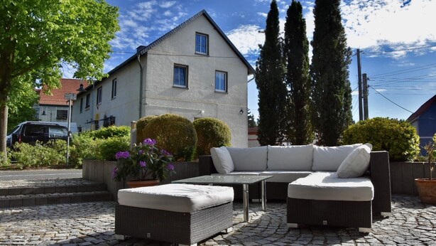 A patio with a sofa set, a table, and potted plants. - Apartment Faupel (Mülverstedt)
