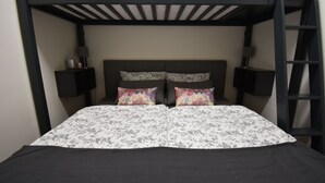 A bunk bed with two pillows, a bedside table, and a ladder. - Apartment Faupel (Mülverstedt)