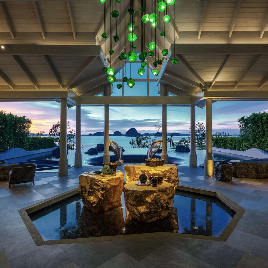 A spacious outdoor area with a pool, seating, and a view of the mountains.