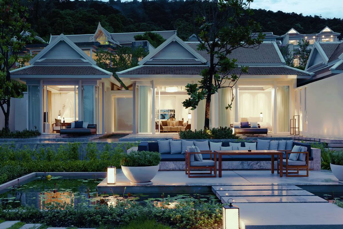 A modern villa with a large outdoor seating area, a swimming pool, and a well-maintained garden.