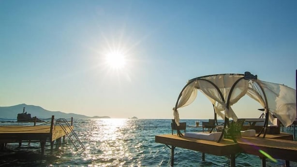 A sunlit pier with a canopy and seating, overlooking calm waters and distant mountains. - Palmalife Bodrum Resort & Spa (Bodrum)