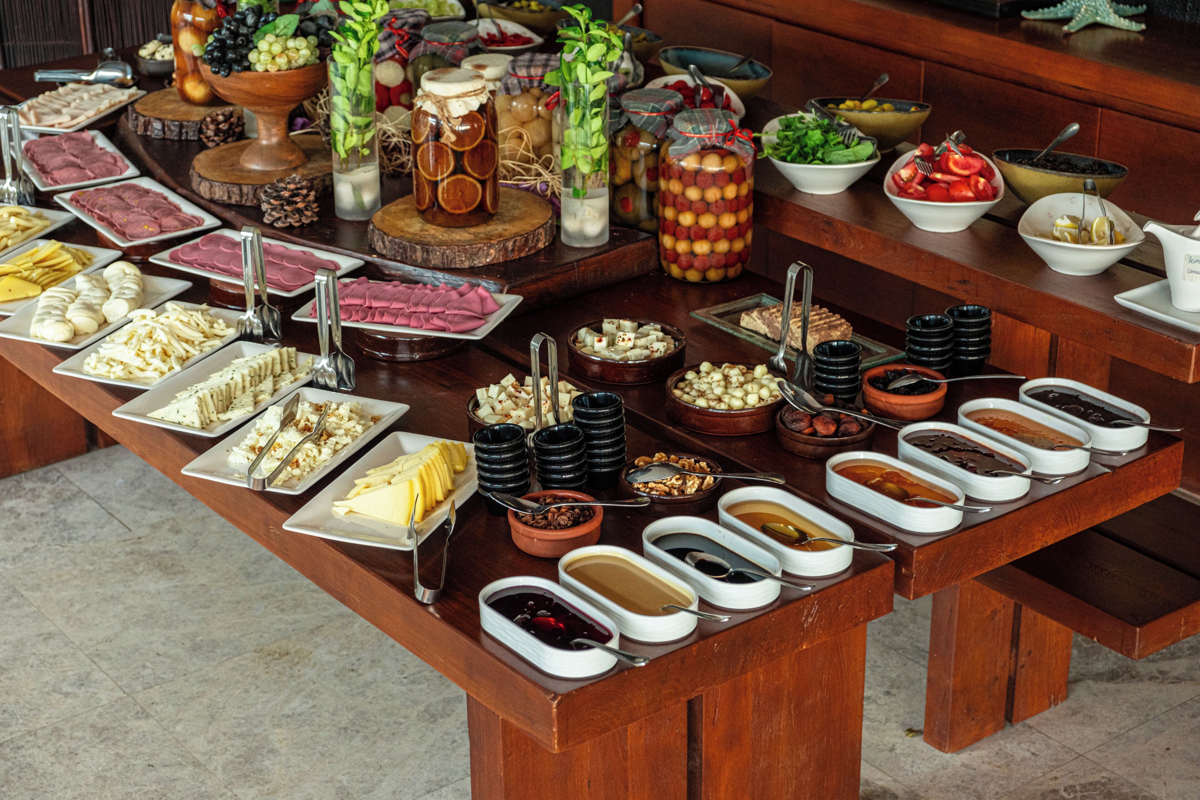 A buffet table with various food items and condiments.