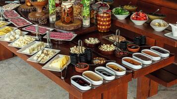 A buffet table with various food items and condiments.
