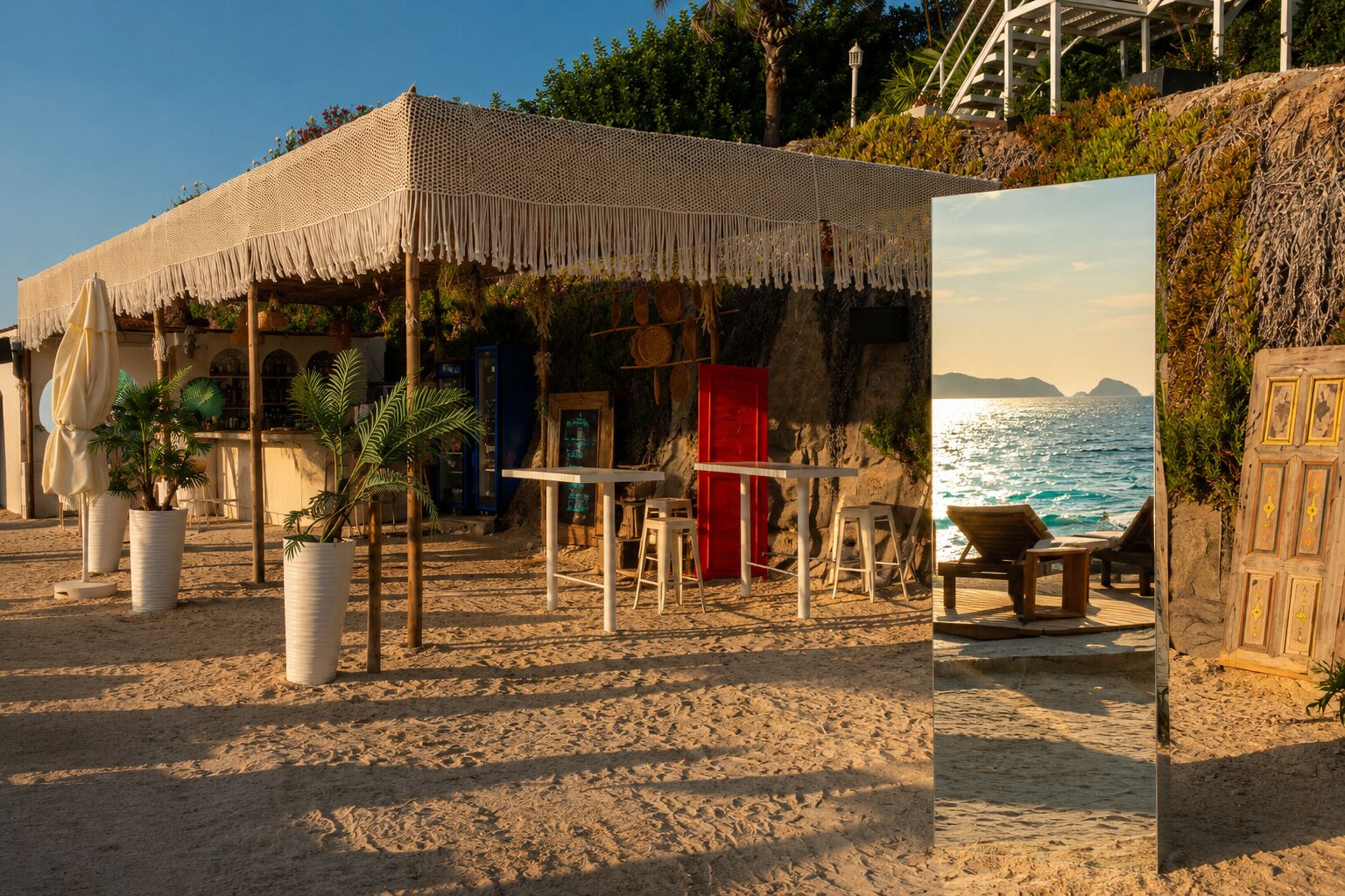 Un café frente al mar con terraza, una mesa de madera y vista al océano.