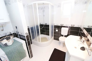 Ein Badezimmer mit Dusche, Toilette und Waschbecken.