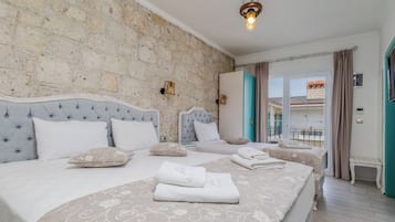 Habitación cuádruple Deluxe | Sábanas de algodón egipcio, ropa de cama de alta calidad y minibar