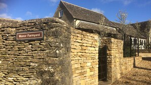 A stone building with a sign reading "Manor Farmyard."