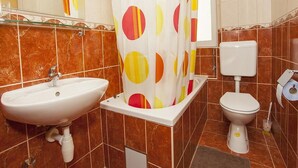 Une salle de bain avec un lavabo blanc, des toilettes et un rideau de douche à motifs à pois.
