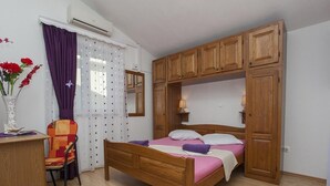 Une chambre à coucher avec un lit en bois, une chaise, un bureau et une armoire.