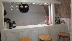 A bar area with two stools, a wine rack, and a mirror.