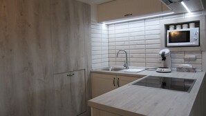 A modern kitchen with a built-in microwave, a coffee machine, and a sink.