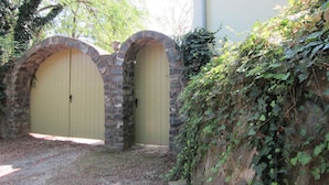 A set of two arched stone doors with a yellow door.