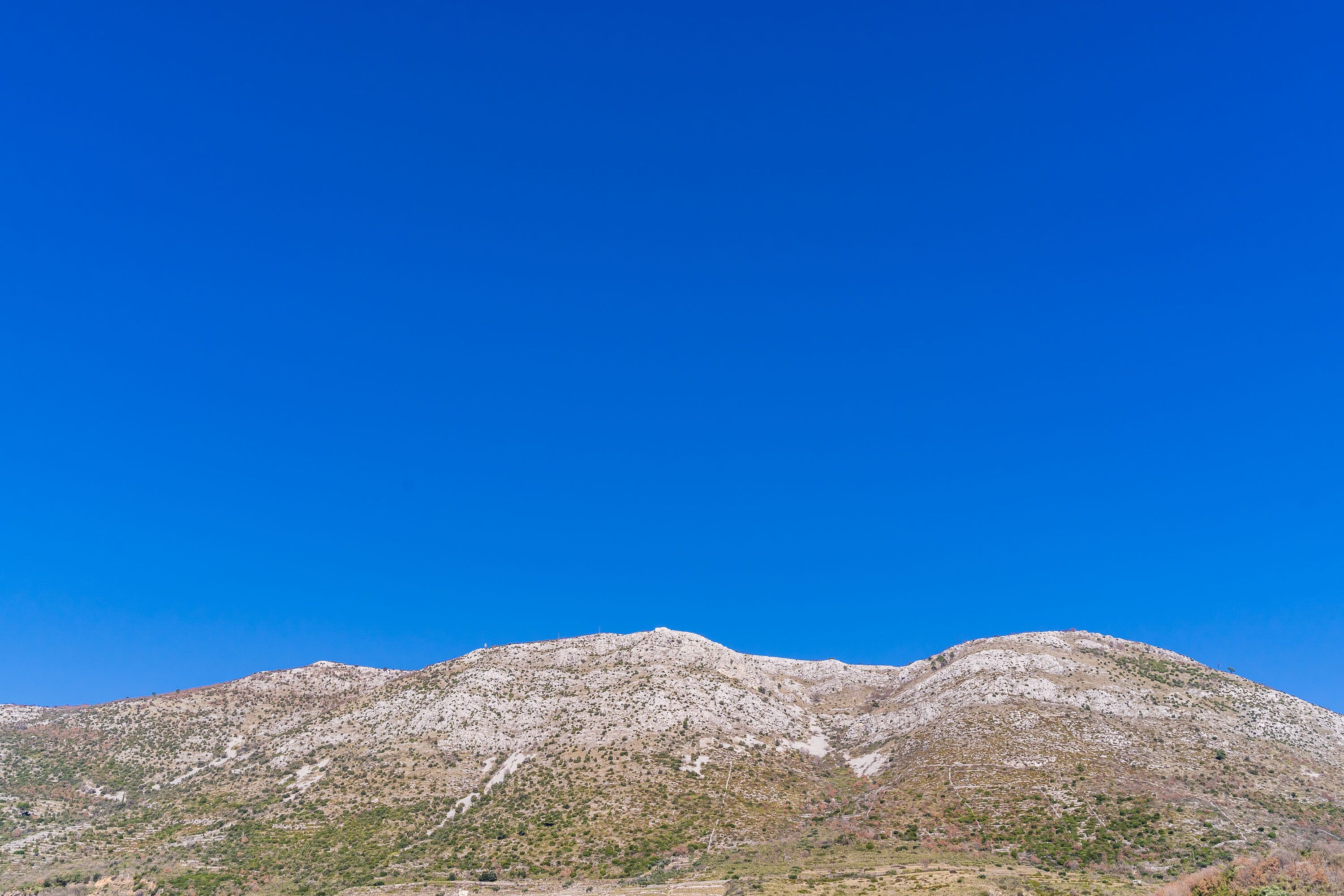 Una montaña bajo un cielo azul despejado.