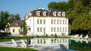 A large, white building with multiple windows and a symmetrical facade.