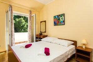 Relax in a spacious room with a large bed, nightstand, and window with curtains, featuring a beautiful painting above.