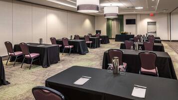 A conference room with multiple tables and chairs, equipped with nameplates and water pitchers.