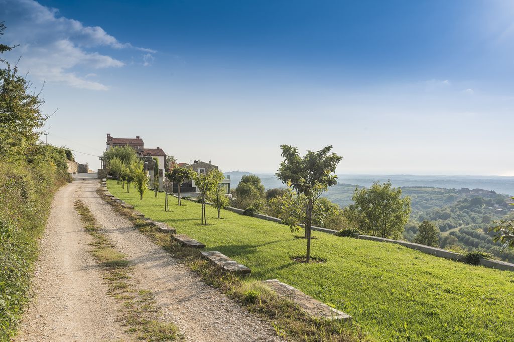 Un sendero de tierra que lleva a una colina con un edificio y árboles.