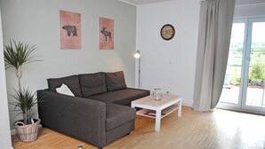 Ein modernes Wohnzimmer mit einem grauen Sofa, einem weißen Couchtisch und zwei an der Wand befestigten Tierdrucken.