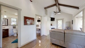 A spacious living area with a ceiling fan, a large sofa, and a view of the outdoors.