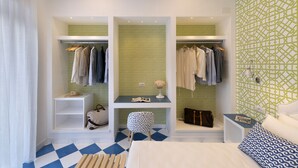 A bedroom with a bed, a desk with a chair, a wardrobe, and a bathroom with a shower curtain. - Design Holiday Home in Sorrento city center (Sorrento)