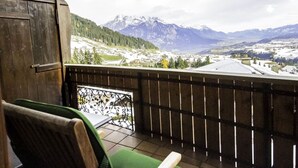Ein Balkon mit Blick auf schneebedeckte Berge und eine darunterliegende Stadt.