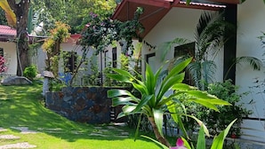 A garden with a stone pathway, green grass, and flowering plants. - Tran Chau Garden Home (Hai Phong)