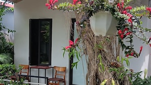A garden with a stone pathway, chairs, and a hanging lantern. - Tran Chau Garden Home (Hai Phong)
