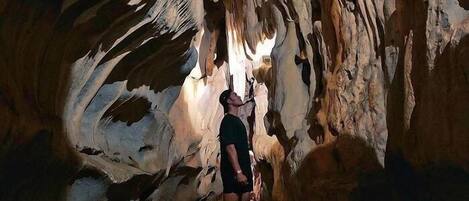 A person standing in a cave with natural rock formations.
