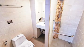 A bathroom with a toilet, sink, and shower.