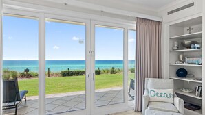 A room with a view of the ocean, a chair with a cushion, and a bookshelf. - Adagio A101 | Private Beach | Ground Floor Unit | 2 pools | Bonus Bunk Room!! (Santa Rosa Beach)