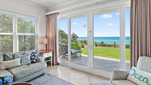 A spacious living room with a large sliding glass door leading to a balcony with a view of the ocean. - Adagio A101 | Private Beach | Ground Floor Unit | 2 pools | Bonus Bunk Room!! (Santa Rosa Beach)