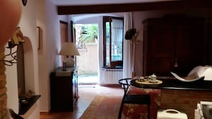 Una cocina acogedora con una mesa de comedor, una lámpara y vistas al jardín a través de la puerta abierta.