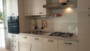 A kitchen with a built-in oven, gas stove, and stainless steel cabinets.