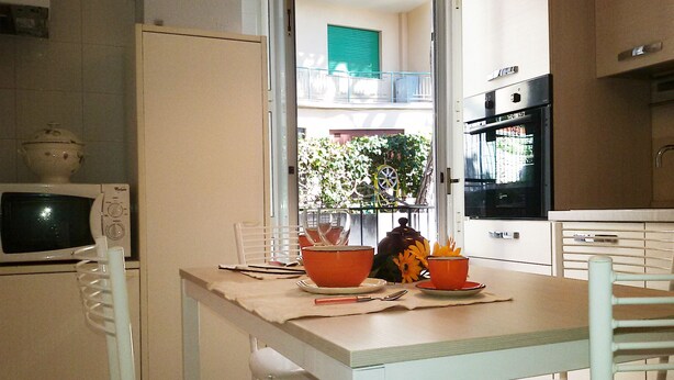 A small kitchen with a dining table, chairs, a microwave, and a refrigerator.