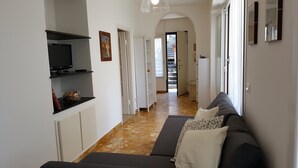 A hallway with a sofa, TV, and shelves. - Casa Agrumeto (Genoa)