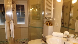 Une salle de bain équipée d’une douche, de toilettes, d’un lavabo et d’un miroir.
