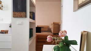A modern living room with a sofa, a coffee table, and a staircase leading to another level. - House Betta (Genoa)